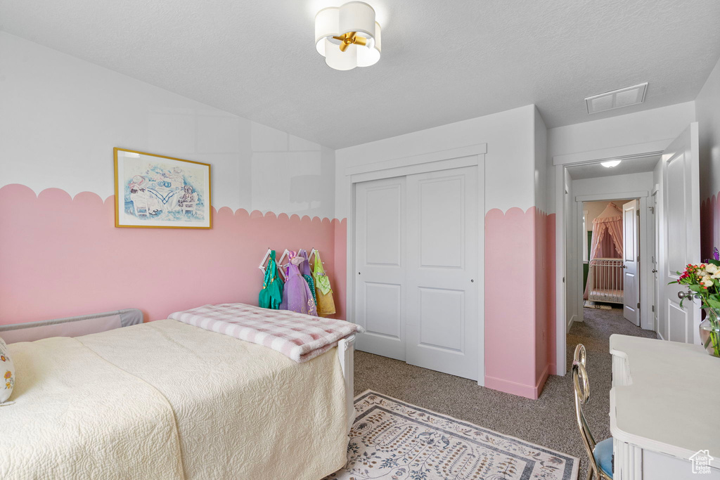 Carpeted bedroom with a closet