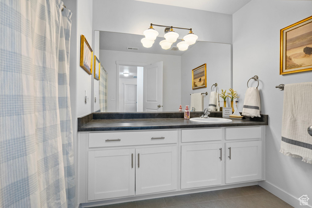 Full bathroom featuring tile patterned flooring, vanity, and baseboards