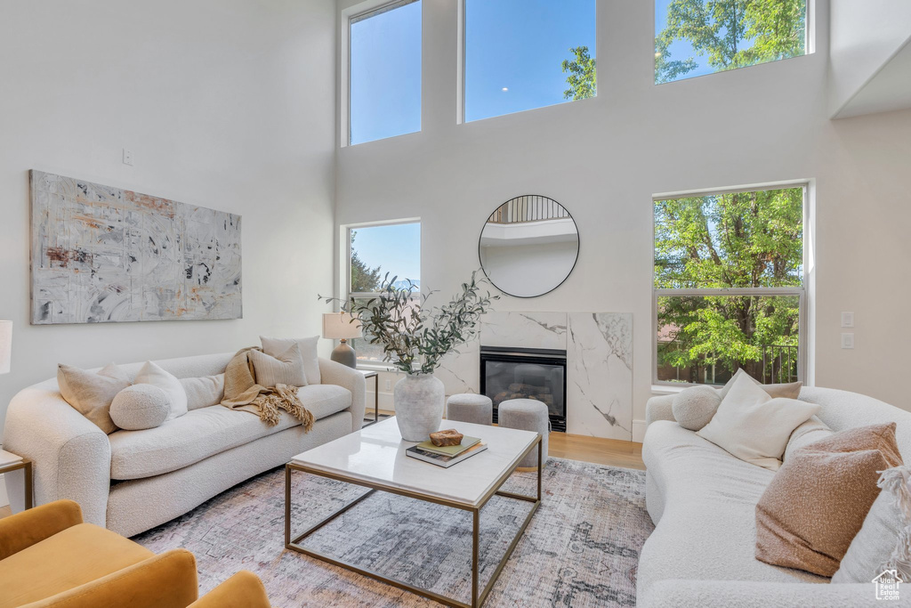 Living area with a high ceiling, a fireplace, and wood finished floors