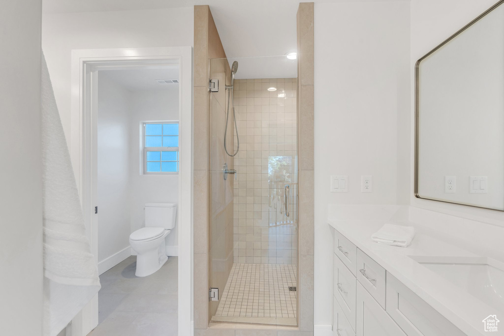 Bathroom featuring a stall shower, toilet, baseboards, and vanity