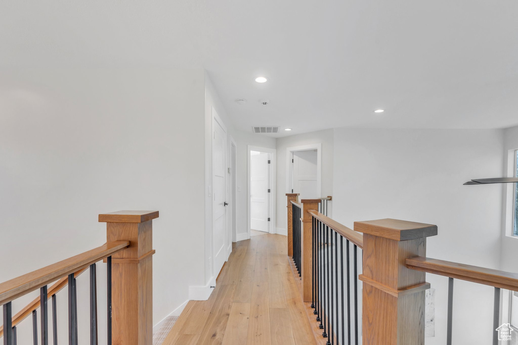 Hallway featuring an upstairs landing, light wood finished floors, recessed lighting, and baseboards