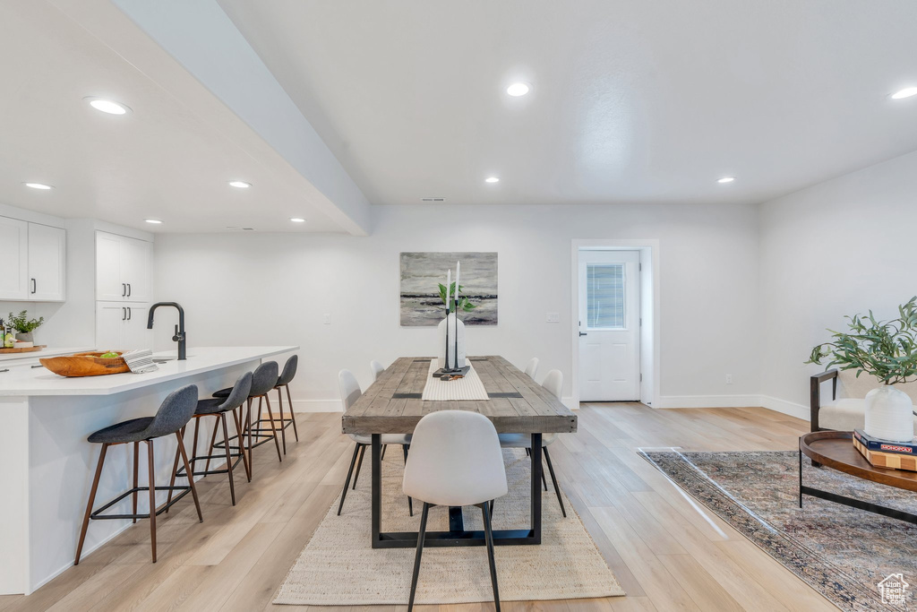 Dining area featuring baseboards, light wood-type flooring, and recessed lighting