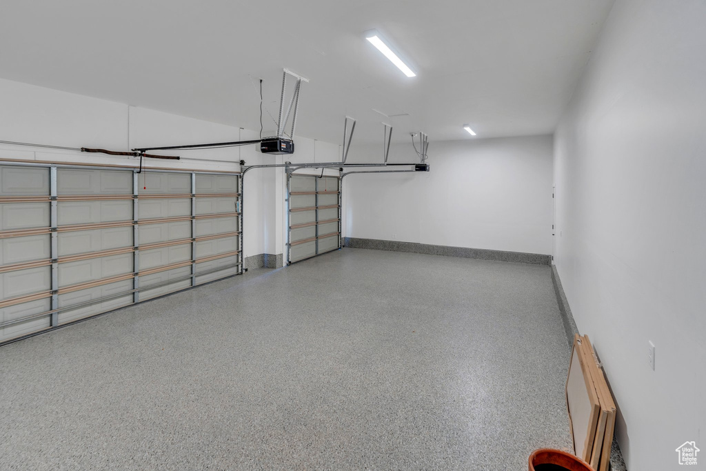 Garage with a garage door opener and baseboards