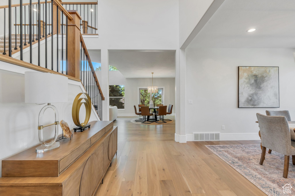 Entryway with stairway, light wood-type flooring, baseboards, recessed lighting, and a chandelier