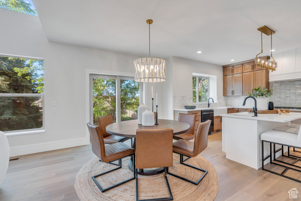 Dining space featuring a chandelier, light wood-style floors, recessed lighting, and baseboards