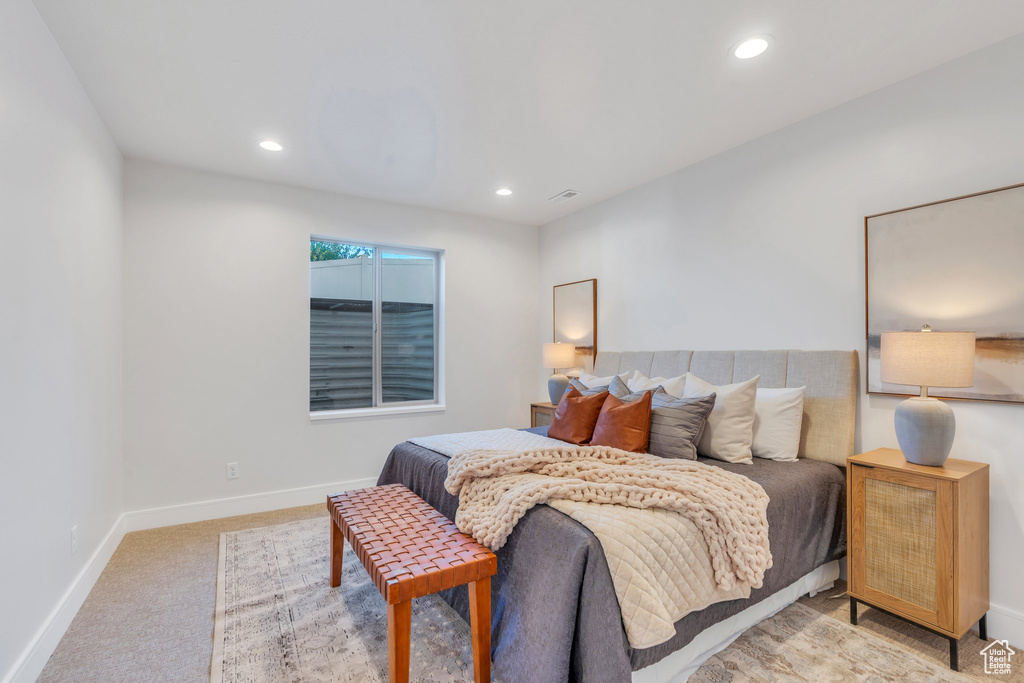 Bedroom with light colored carpet, baseboards, and recessed lighting