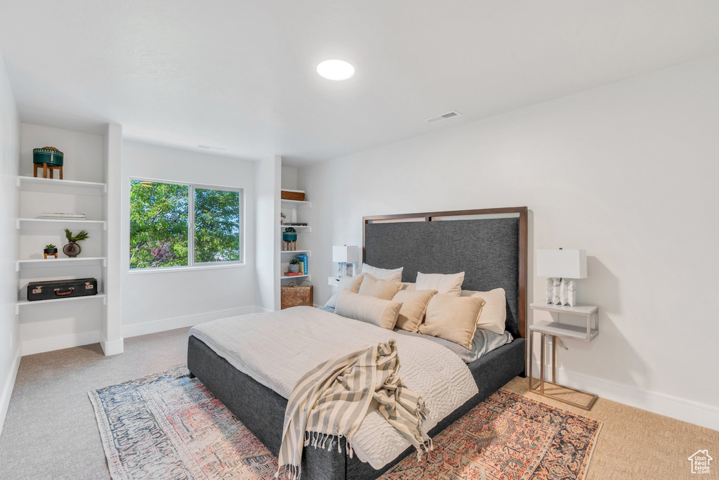 Bedroom with baseboards and light colored carpet