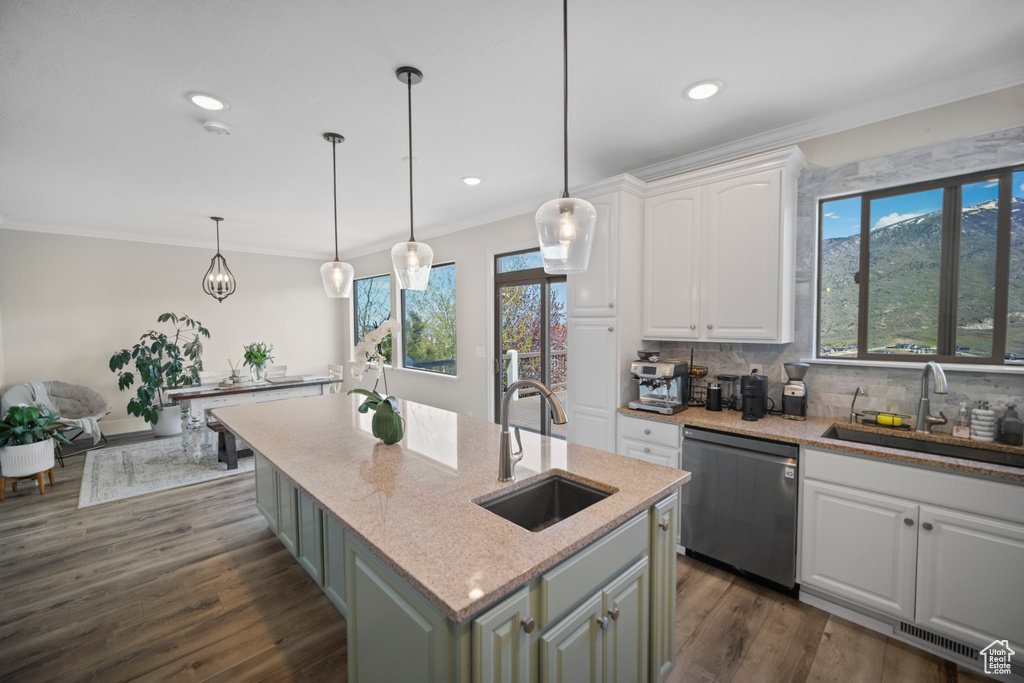 Kitchen featuring stainless steel dishwasher, a sink, ornamental molding, white cabinetry, and light stone countertops