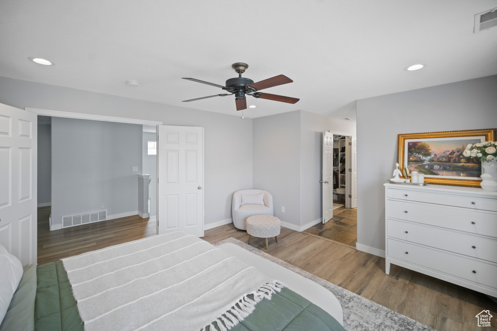 Bedroom featuring baseboards, wood finished floors, recessed lighting, ceiling fan, and a spacious closet