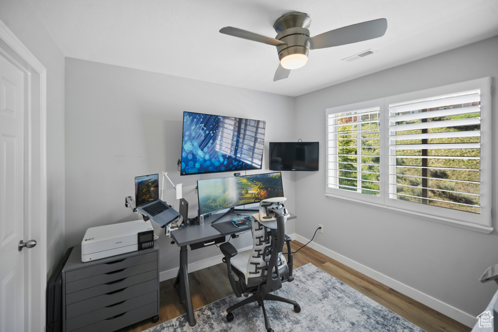 Office area with baseboards, ceiling fan, and wood finished floors