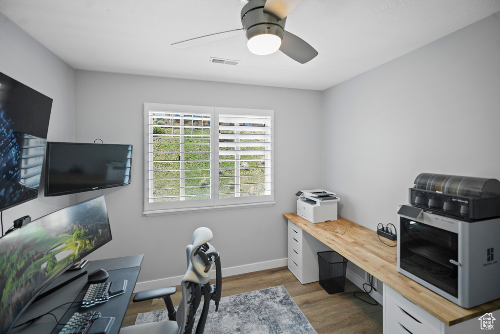 Office area featuring wood finished floors, ceiling fan, and baseboards