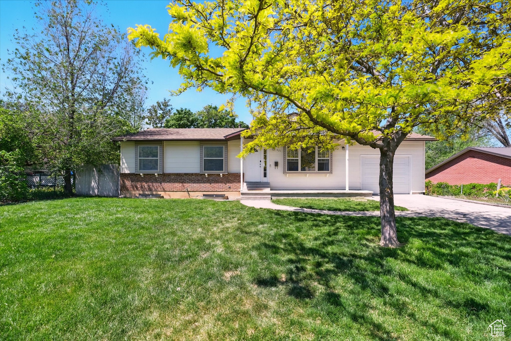 View of front of home with brick siding, an attached garage, and concrete driveway