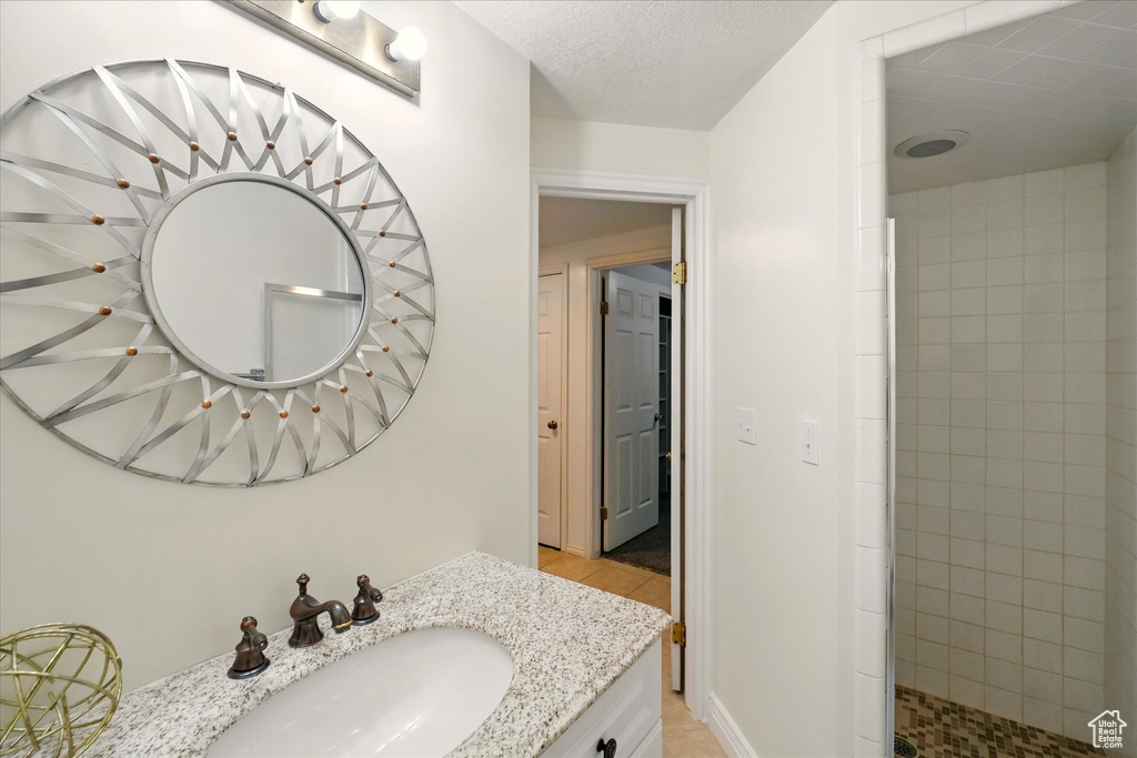 Full bath with a tile shower and vanity