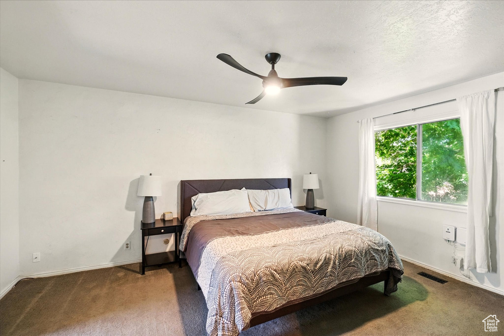Carpeted bedroom with baseboards and ceiling fan