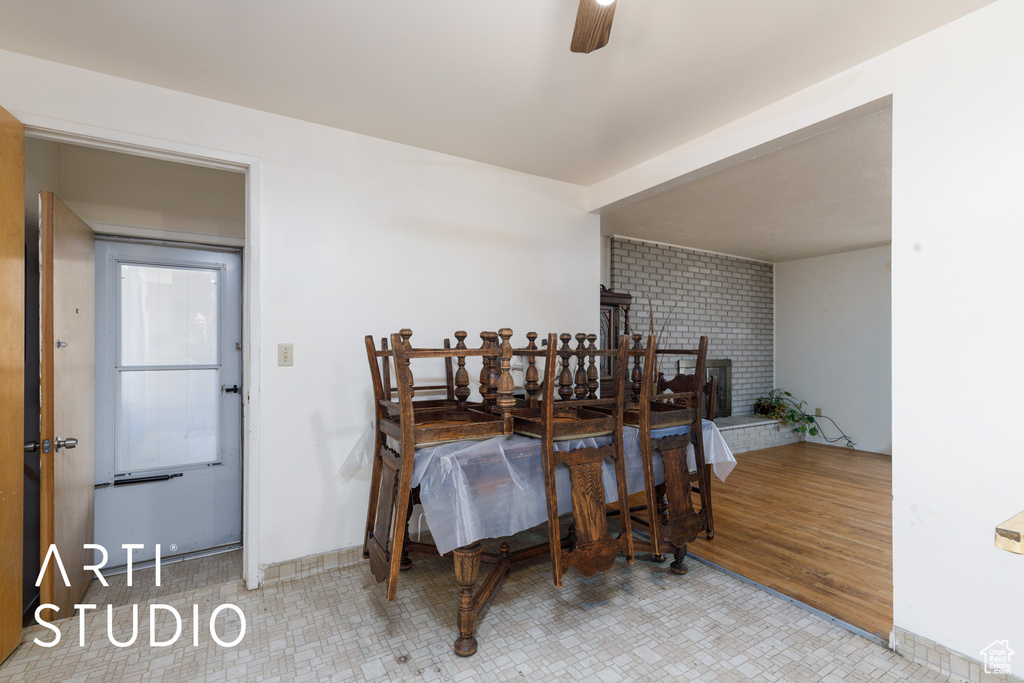 Dining space featuring ceiling fan and a brick fireplace