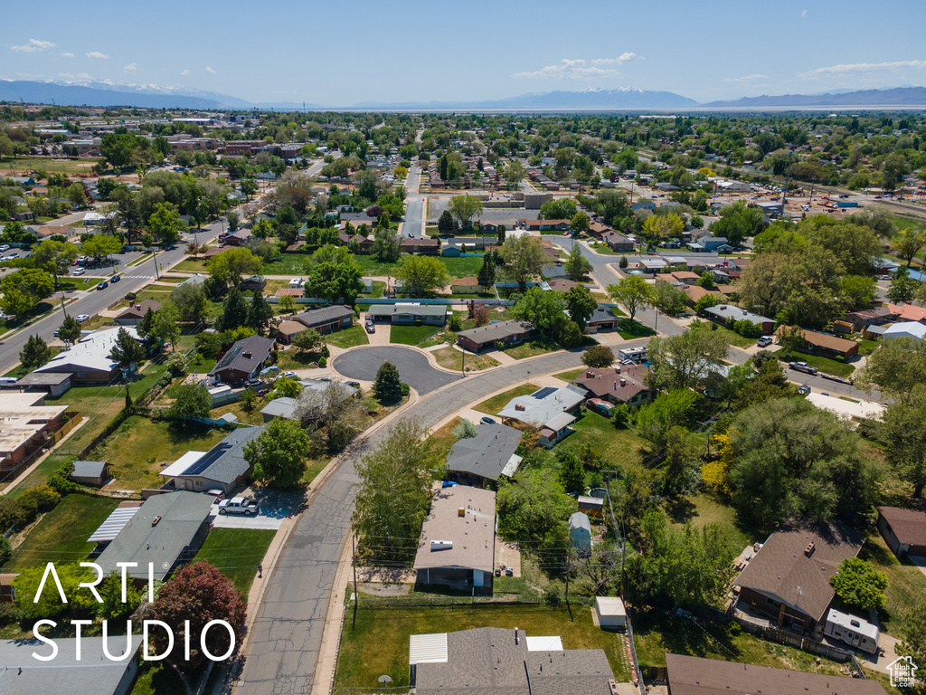 Aerial view of property and surrounding area with nearby suburban area and mountains