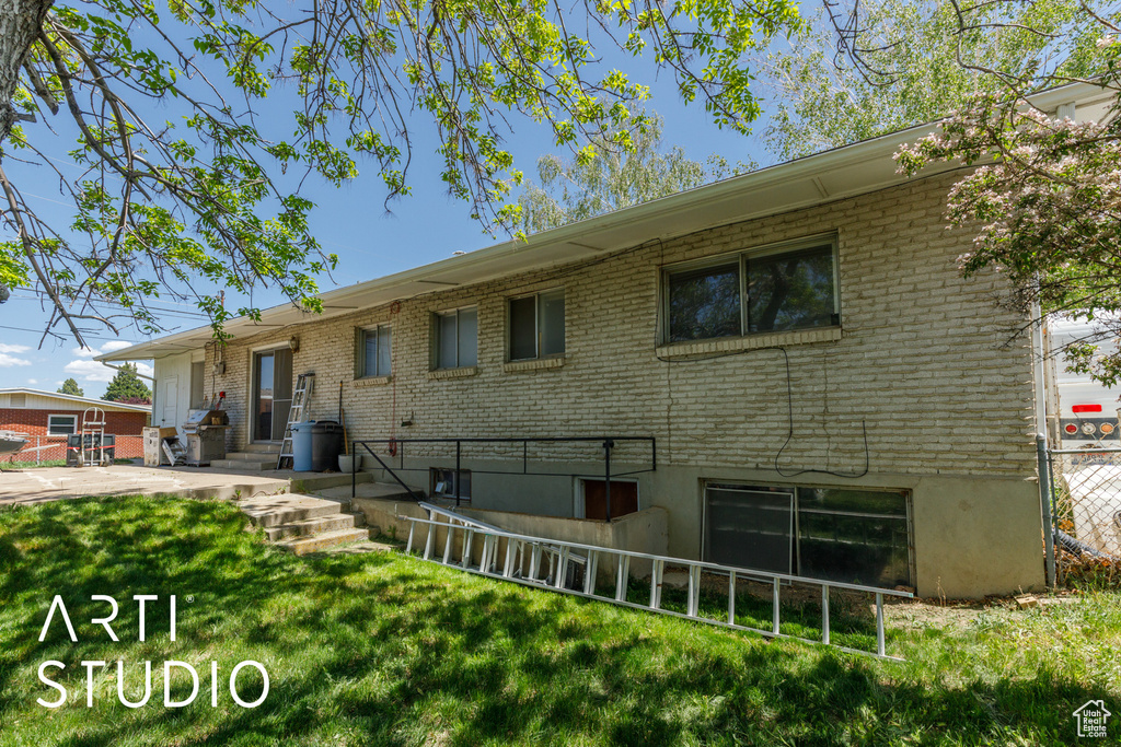 Back of property featuring brick siding and a yard