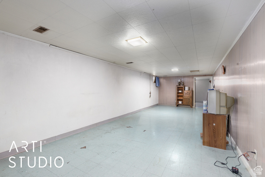 Finished below grade area featuring tile patterned floors, wooden walls, and baseboards