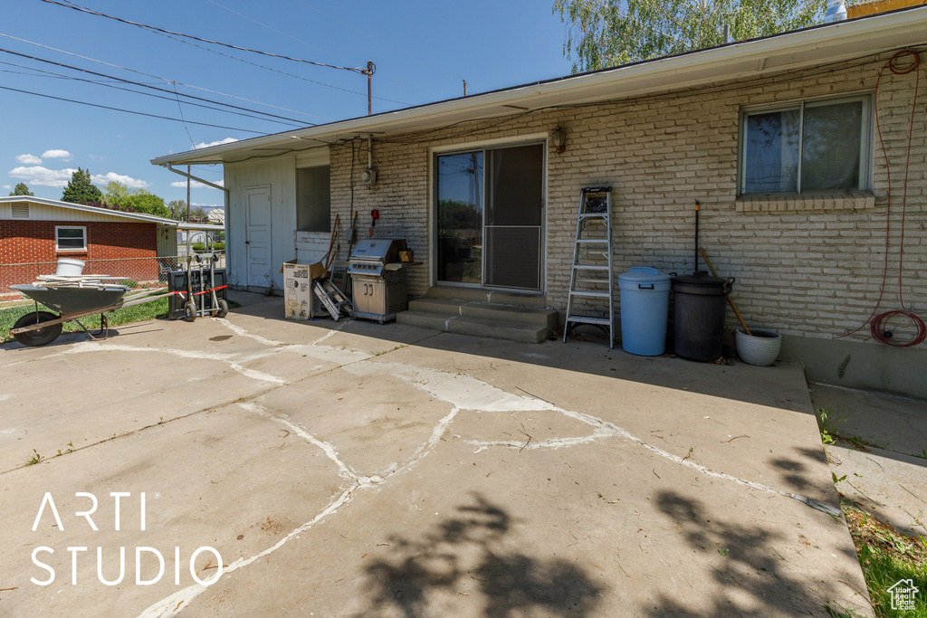 Rear view of house featuring brick siding, a patio, and entry steps