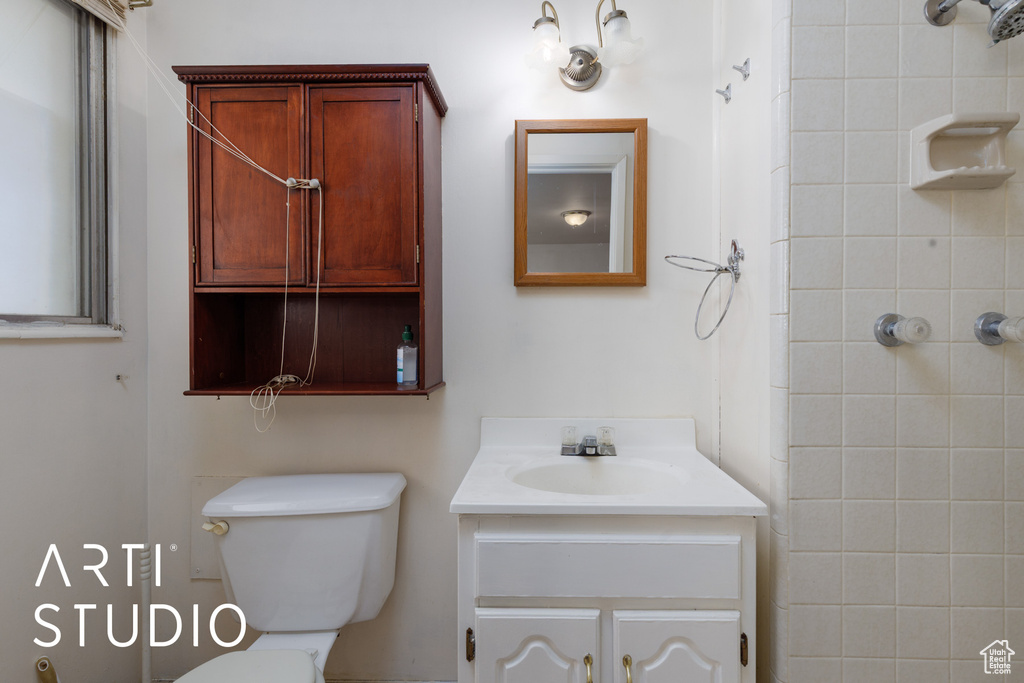 Bathroom with vanity, toilet, and a shower