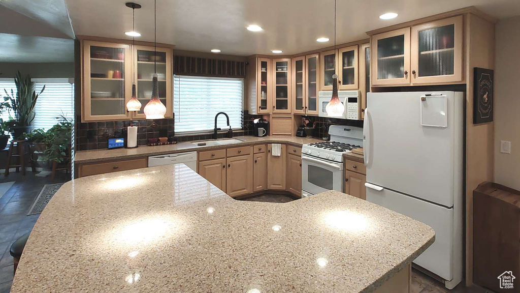 Kitchen featuring white appliances, a sink, healthy amount of natural light, recessed lighting, and decorative backsplash