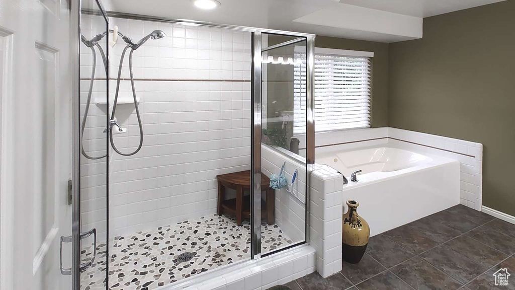 Bathroom featuring a stall shower, a garden tub, recessed lighting, and baseboards