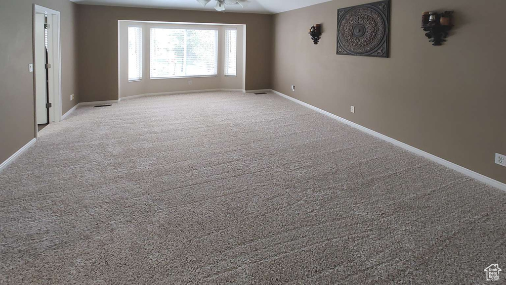 Spare room featuring baseboards and carpet flooring