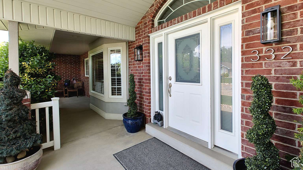Entrance to property with brick siding and covered porch