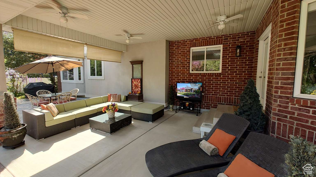 View of patio featuring a ceiling fan, an outdoor living space, and a grill
