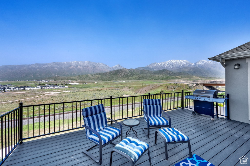 Wooden deck with a grill, a mountain view, and a rural view