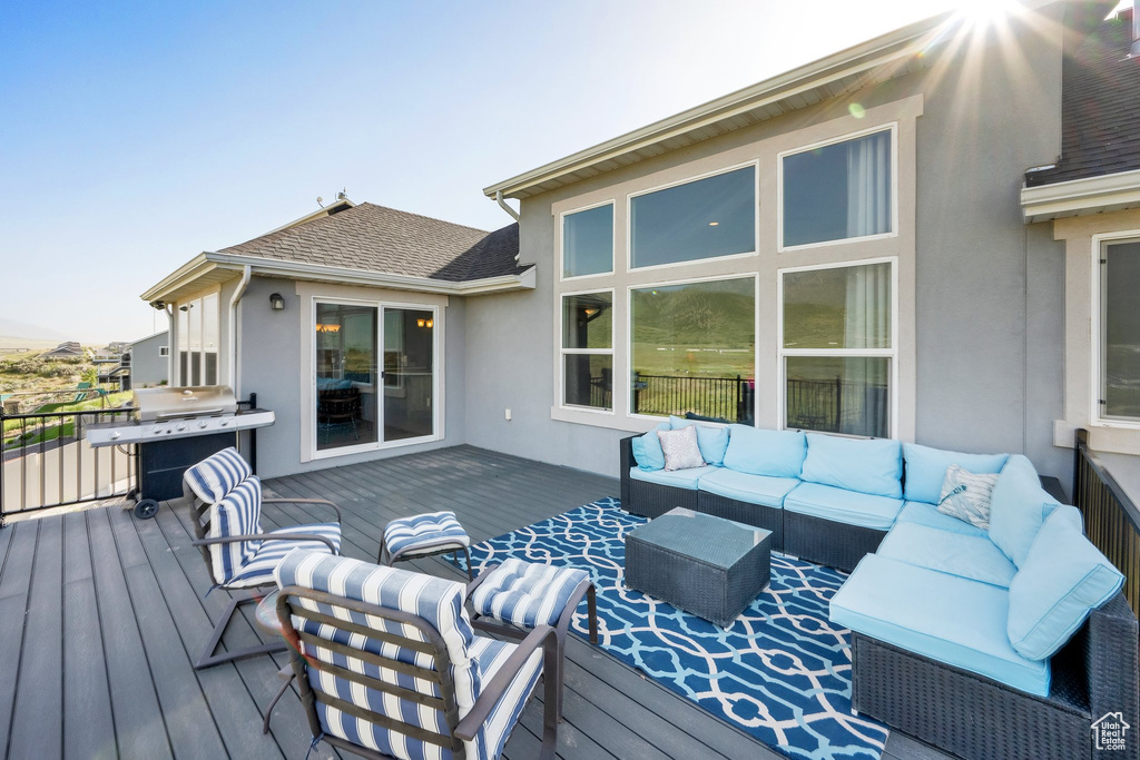 Wooden terrace featuring an outdoor living space and grilling area
