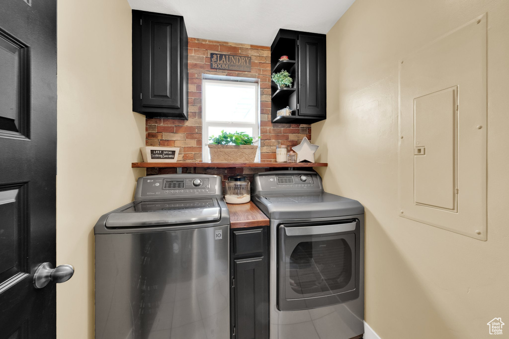 Laundry area featuring cabinet space, washer and dryer, and electric panel