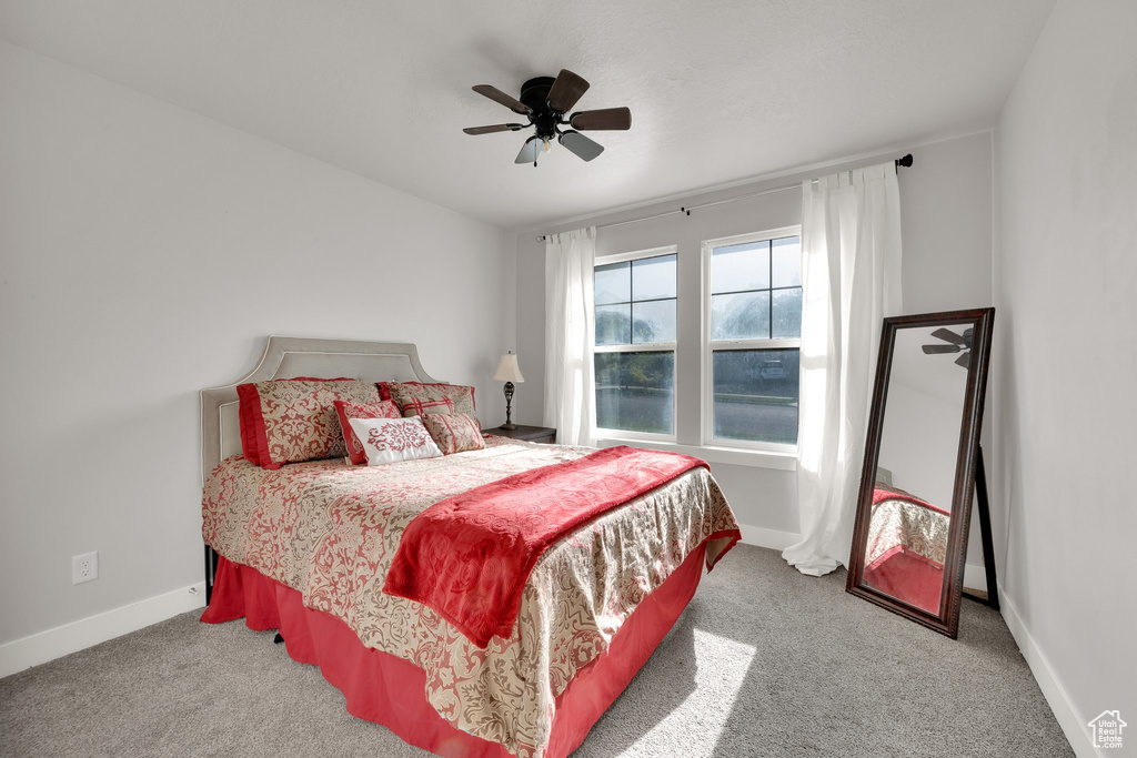Carpeted bedroom with baseboards and a ceiling fan