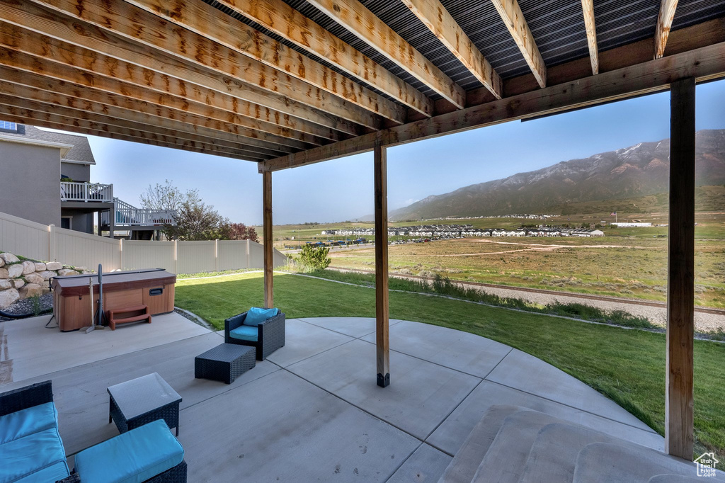 View of patio / terrace with a hot tub and a mountain view