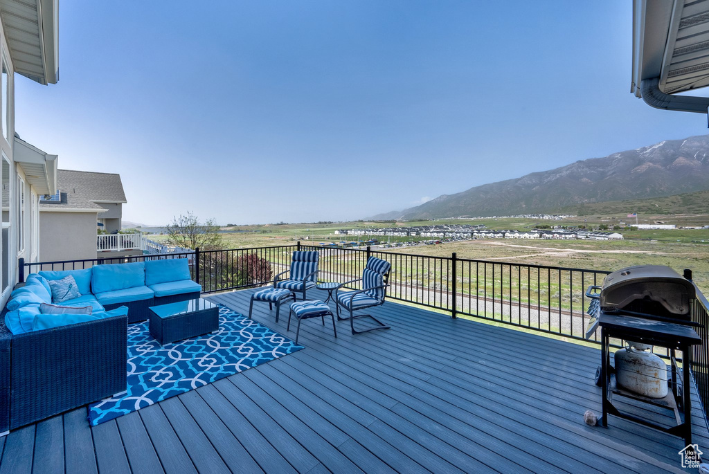 Deck with an outdoor living space, a mountain view, and area for grilling