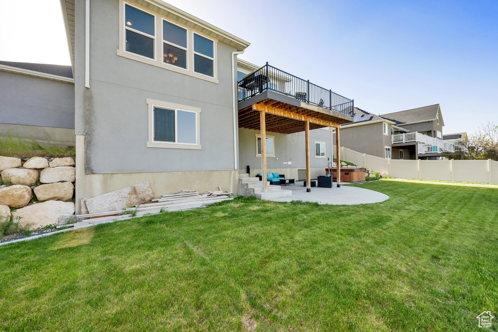 Rear view of house featuring a patio area, a wooden deck, a hot tub, and stucco siding