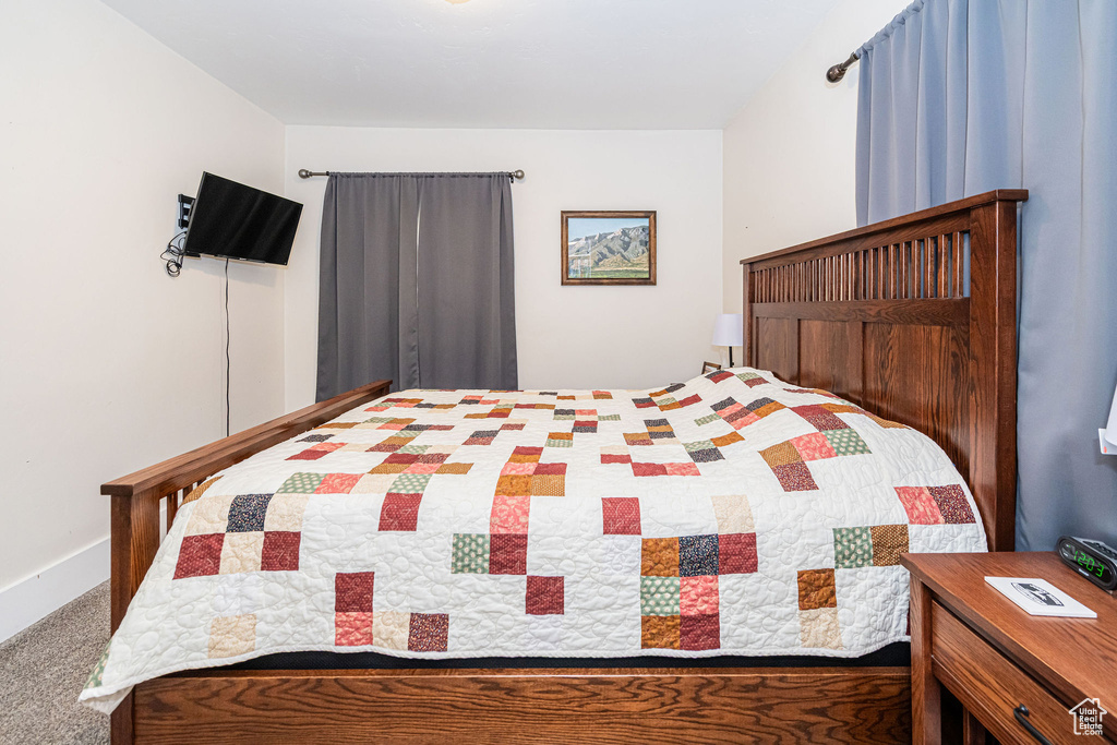 Bedroom featuring carpet floors and baseboards