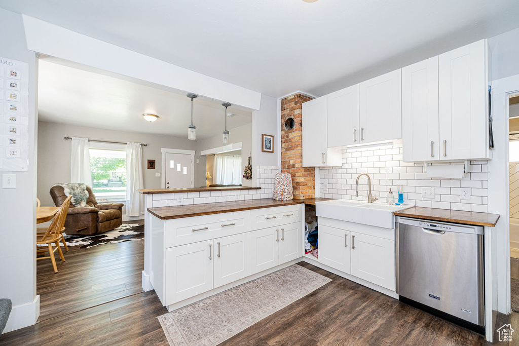 Kitchen featuring dishwasher, wooden counters, a sink, and dark wood-style floors
