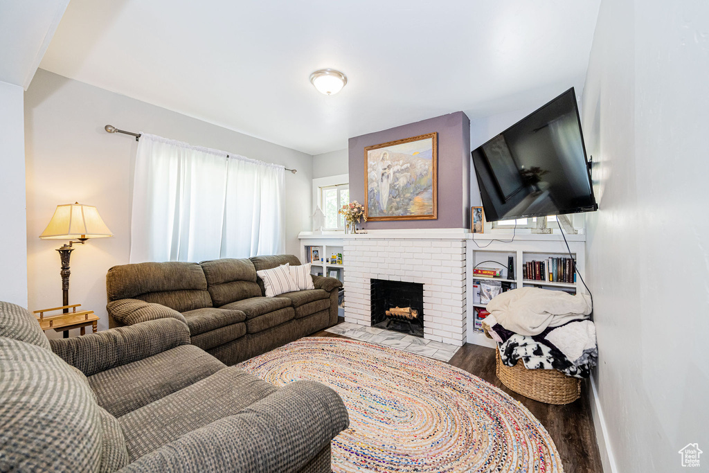 Living room with wood finished floors and a brick fireplace