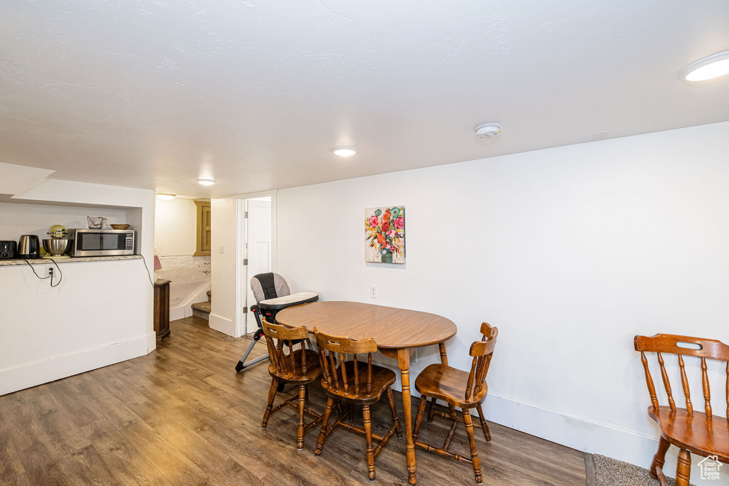 Dining area with wood finished floors, baseboards, and stairway