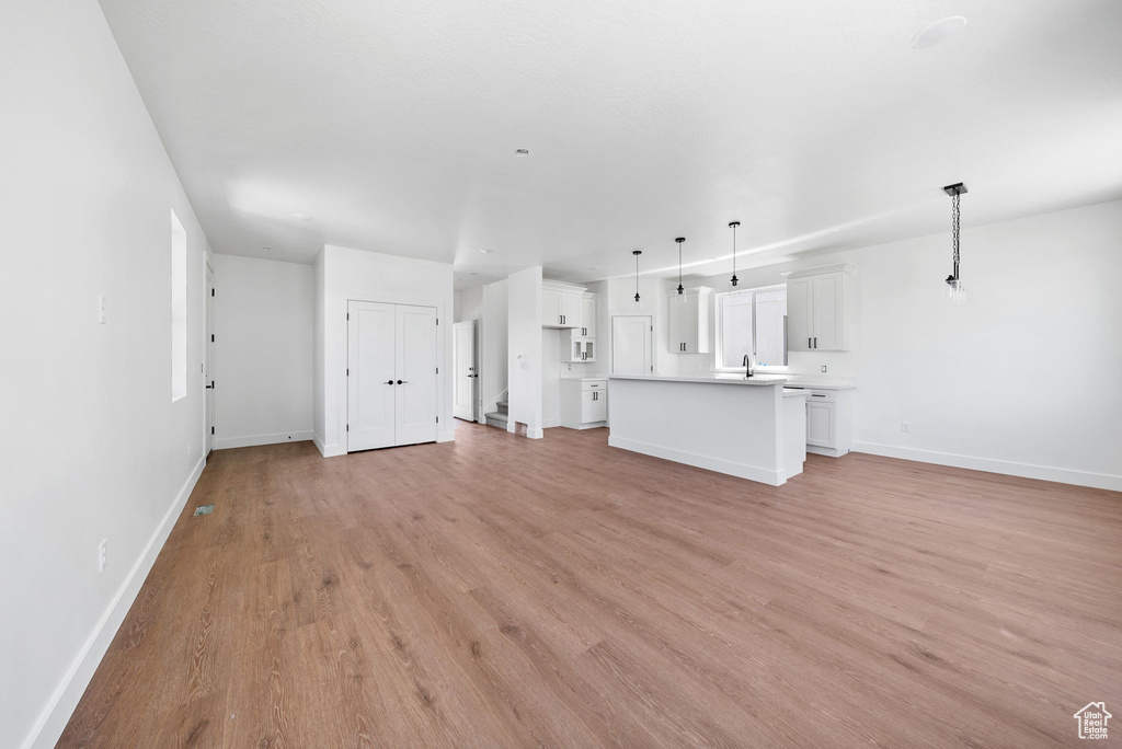 Unfurnished living room with baseboards and light wood finished floors