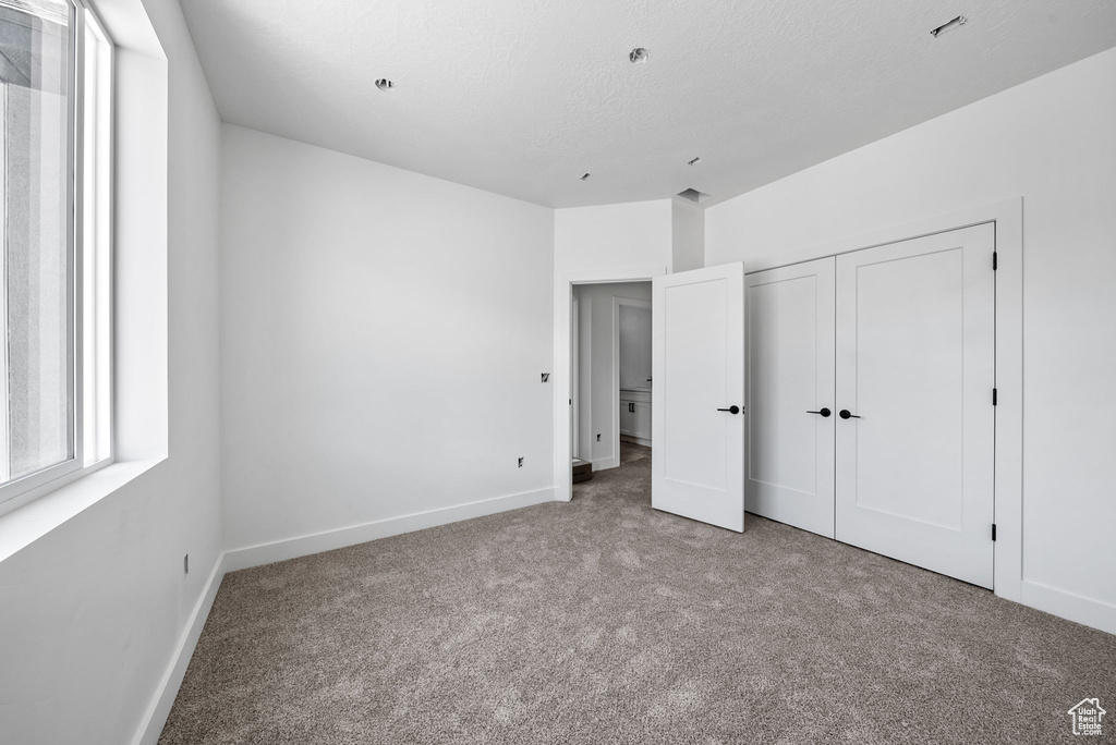 Unfurnished bedroom with carpet and a closet
