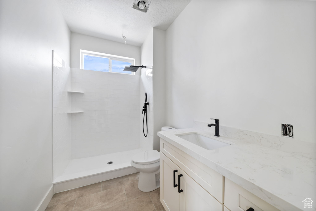 Bathroom with tiled shower and vanity