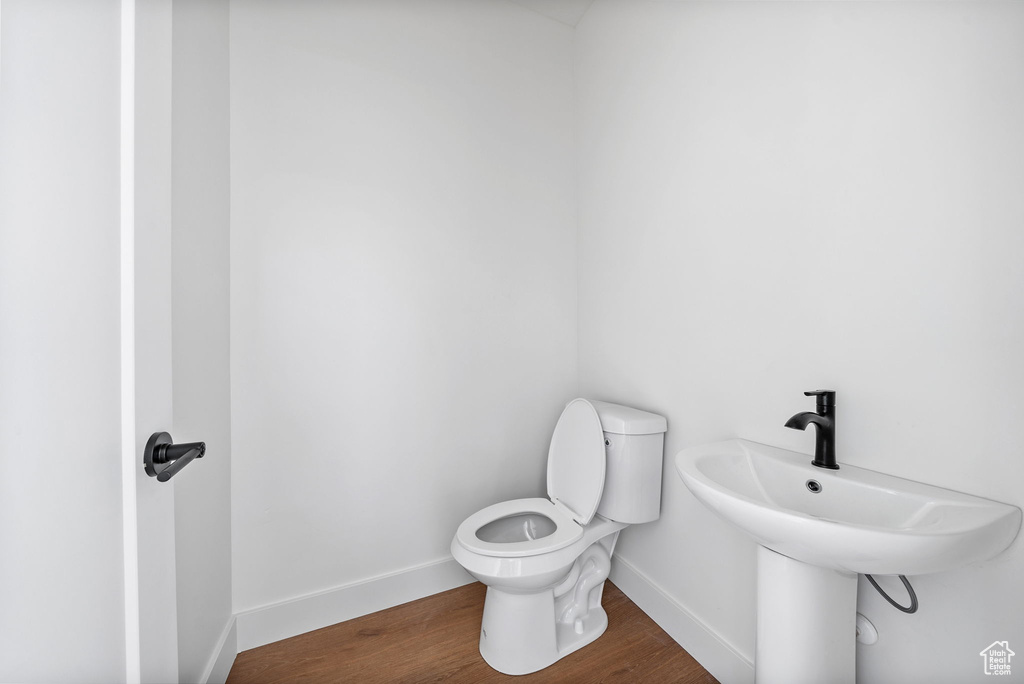 Half bathroom featuring baseboards and wood finished floors