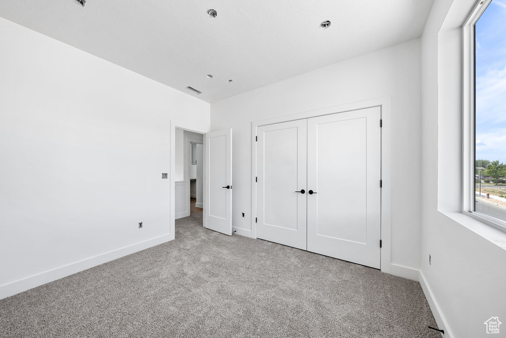 Unfurnished bedroom with carpet flooring and a closet