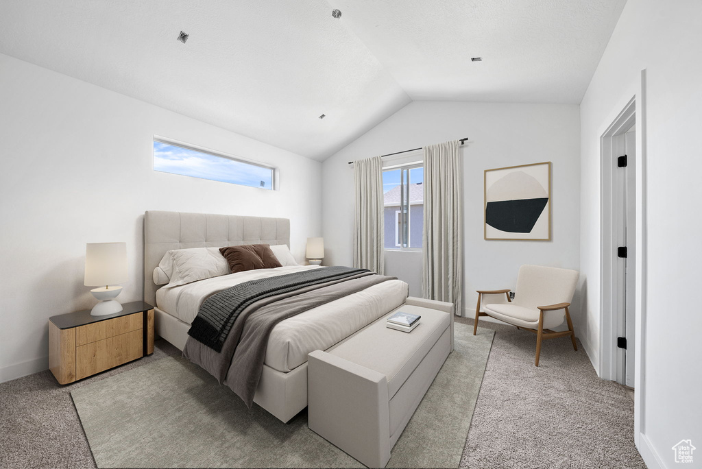 Bedroom with light colored carpet and vaulted ceiling