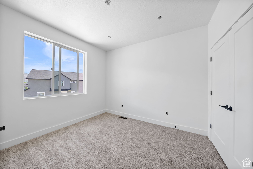 Unfurnished room with carpet floors and baseboards