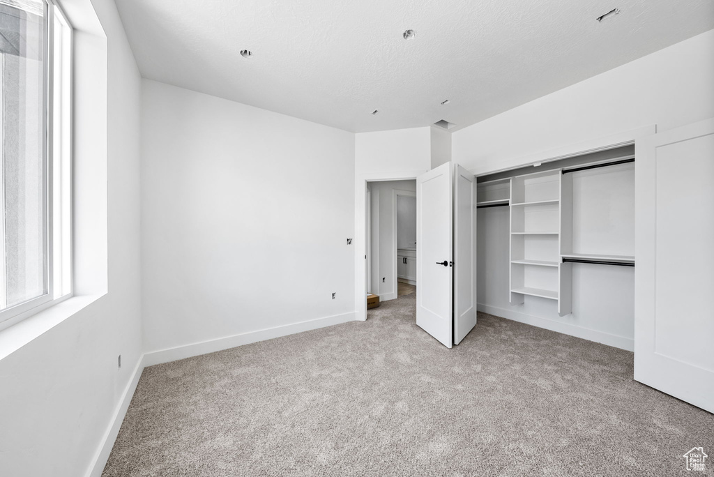 Unfurnished bedroom featuring carpet floors and a closet