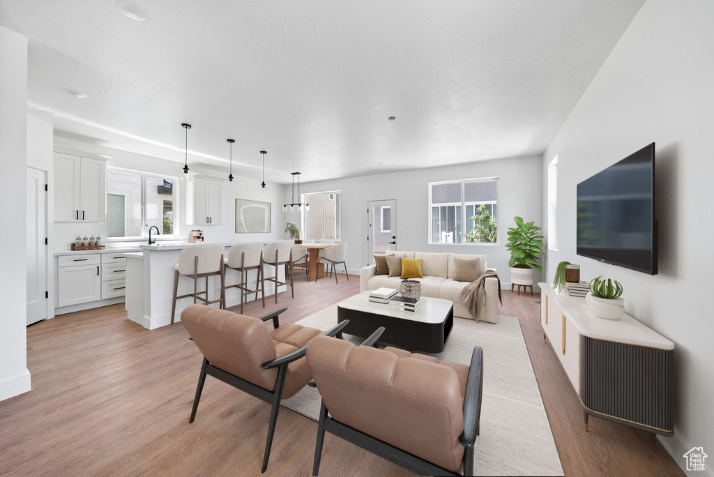 Living room with light wood-style flooring and healthy amount of natural light