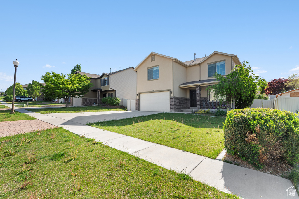 View of front of home featuring a garage, concrete driveway, and stucco siding